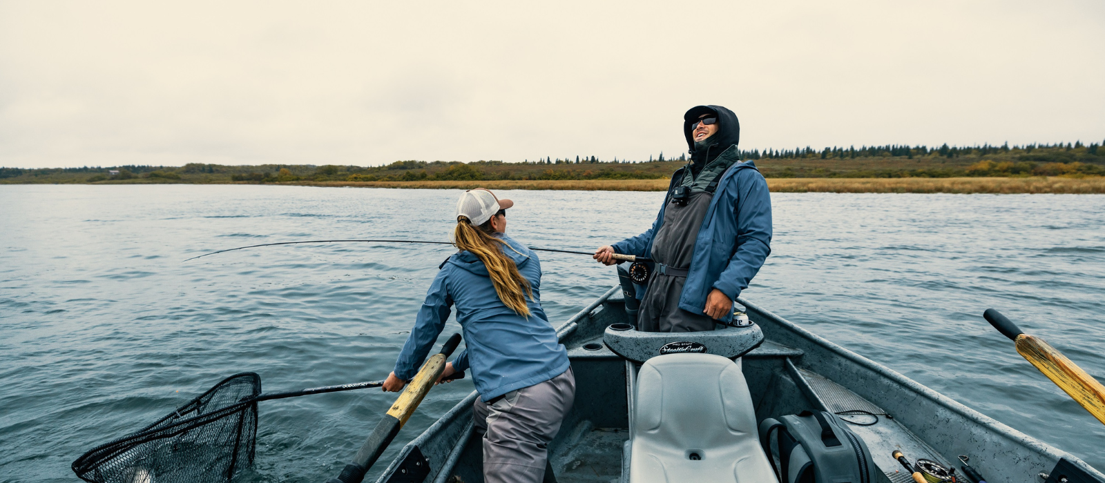 Man and woman fishing in Alaska in cold weather fishing gear