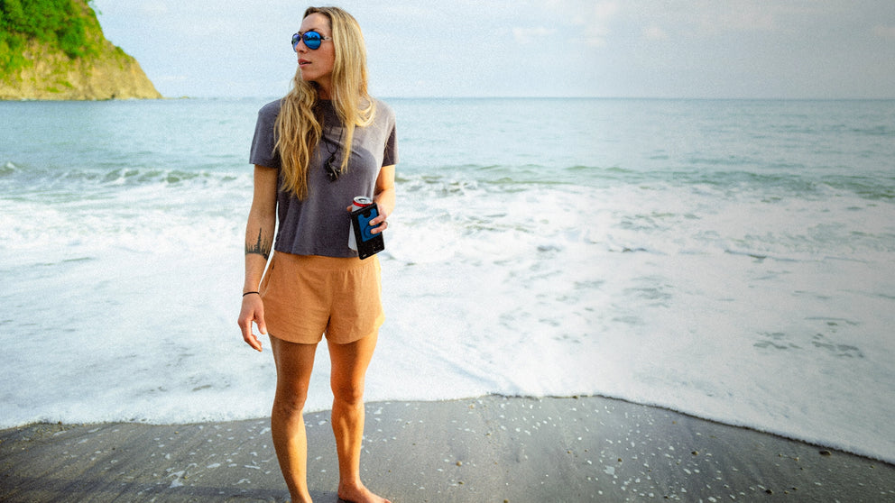 Woman standing on a beach with ocean waves in the background