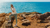 Person standing on rocky terrain by the ocean