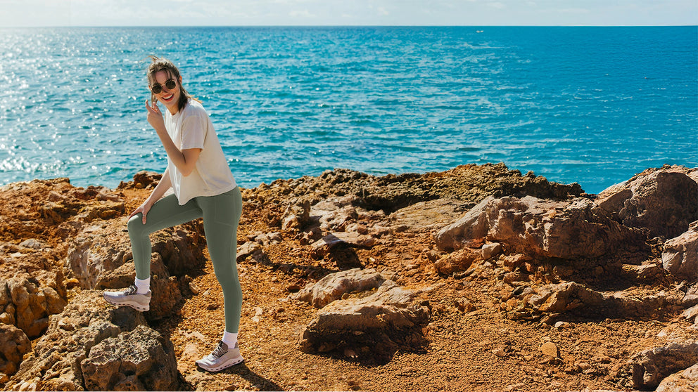 Person standing on rocky terrain by the ocean
