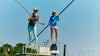 Two women standing on a boat with a clear blue sky in the background